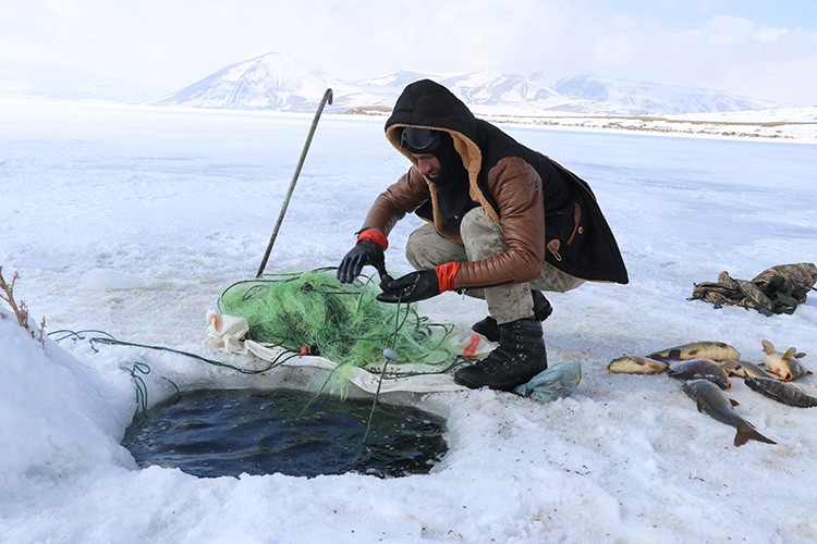 Buzla kaplı gölde balık tutuyorlar